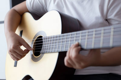 Midsection of man playing guitar