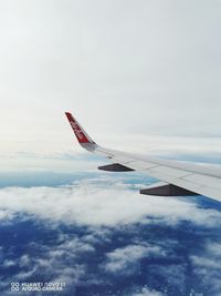 Airplane flying over cloudscape against sky