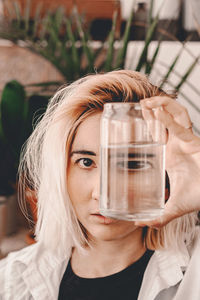 Portrait of woman holding transparent container