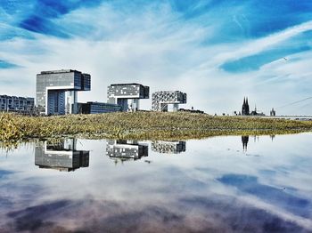 Reflection of buildings in city against sky