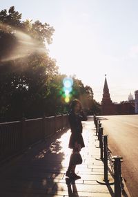 Full length of woman walking on railing during sunny day