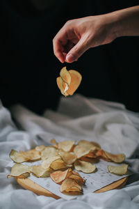 High angle view of hand holding leaves on table