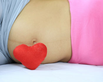 Heart shape against belly of pregnant woman