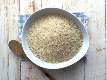 Directly above shot of uncooked rice in bowl on table