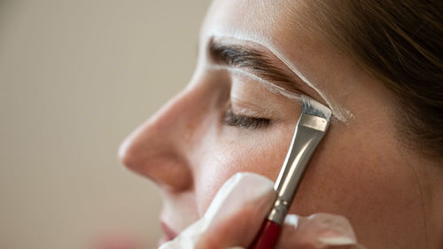 Close-up of woman applying nail