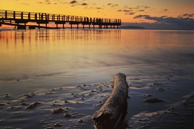 Pier on sea at sunset