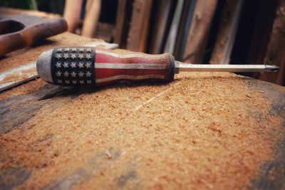 Close-up of american flag on screwdriver at wooden table