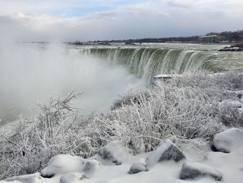 Scenic view of waterfall against sky during winter