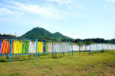 Clothes drying on field against sky