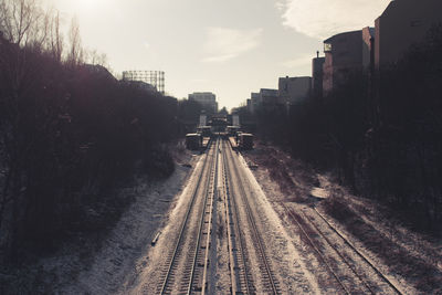 Railway tracks in city against sky