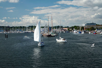 Sailboats in sea against sky