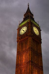 Low angle view of clock tower against cloudy sky