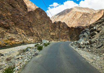 Road amidst rocks against sky