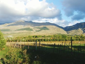 Scenic view of field and mountains against sky