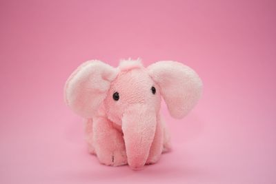 Close-up of stuffed toy over pink background