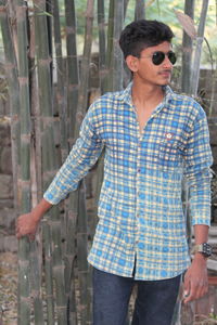 Portrait of young man wearing sunglasses standing outdoors