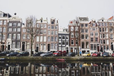 Reflection of buildings in canal against sky