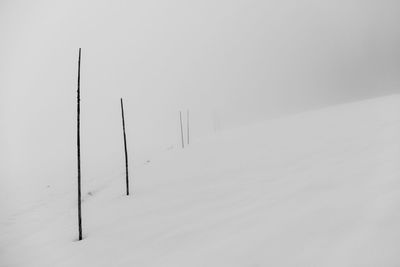 Snow covered wooden post on field during winter