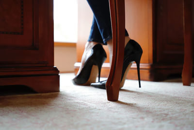 Low section of woman standing on chair