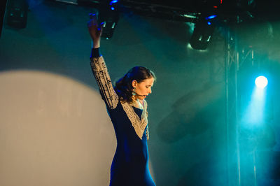 Full length of young woman standing at music concert