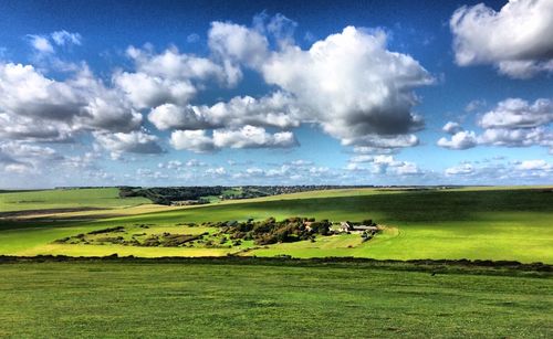 Scenic view of grassy field against cloudy sky