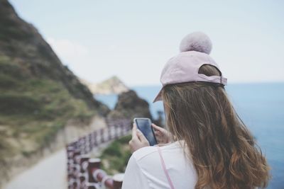 Rear view of woman photographing sea