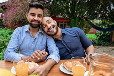 Portrait of smiling friends sitting at park