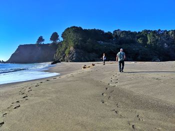 People walking on beach against sky