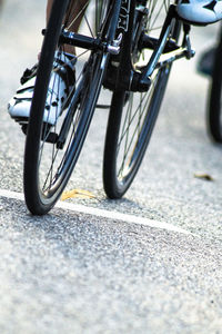 Close-up low section of motorcycle on road