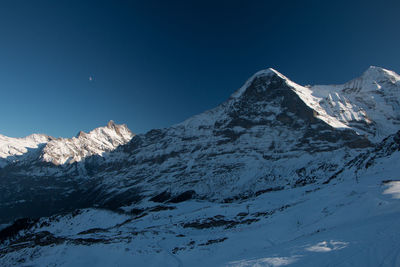 Scenic view of snow covered mountains against clear sky