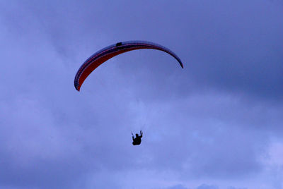 Low angle view of person paragliding against sky