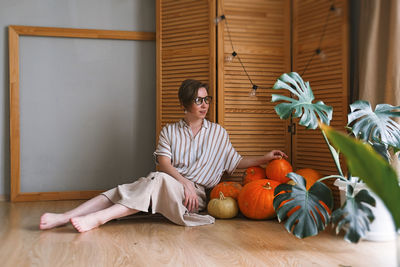 Woman sitting on wooden floor at home