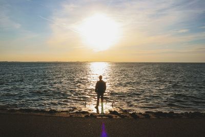 Rear view of silhouette man standing on beach