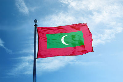 Low angle view of flag against blue sky
