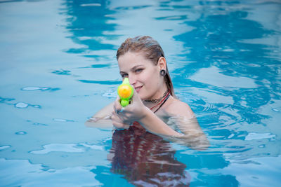 Portrait of young woman swimming in pool