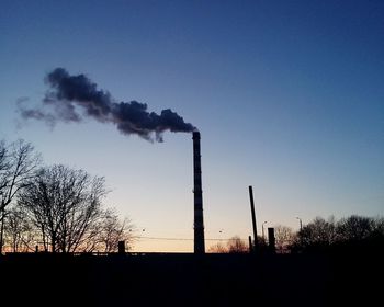 Smoke emitting from chimney against clear blue sky