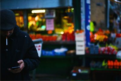 Man using mobile phone in city at night