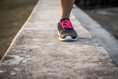 Low section of woman walking on railing