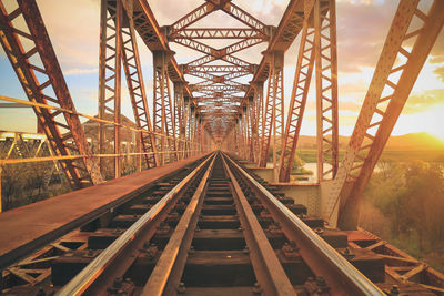 Empty railway bridge against sky during sunset