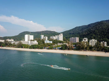 Scenic view of sea and buildings against sky