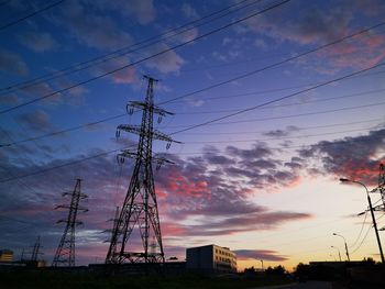 Low angle view of silhouette electricity pylon against sky during sunset