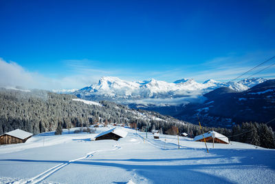 Scenic view of snowcapped mountains against clear blue sky