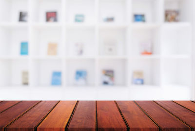 Close-up of wooden table against bookshelves