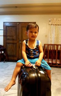 Full length of boy sitting at home