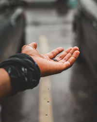 Rain falling on cropped hand
