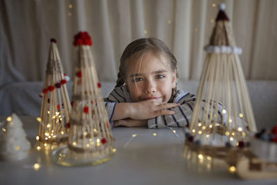 Portrait of girl by illuminated christmas ornaments