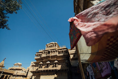 Low angle view of people outside building against blue sky