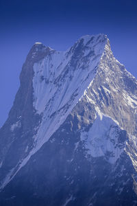 Scenic view of snowcapped mountains against clear blue sky