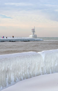 Tourists hike out to see the ice covered light beacon in st joseph mi usa