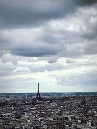 Aerial view of buildings against cloudy sky